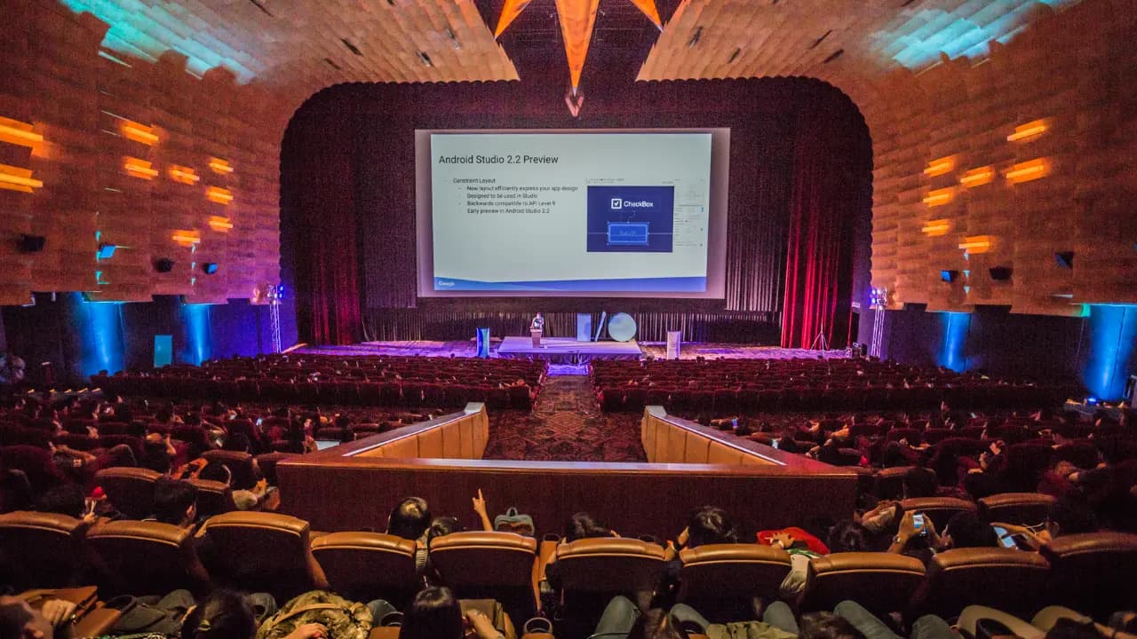 A large auditorium filled with attendees seated in chairs during the Google I/O event.